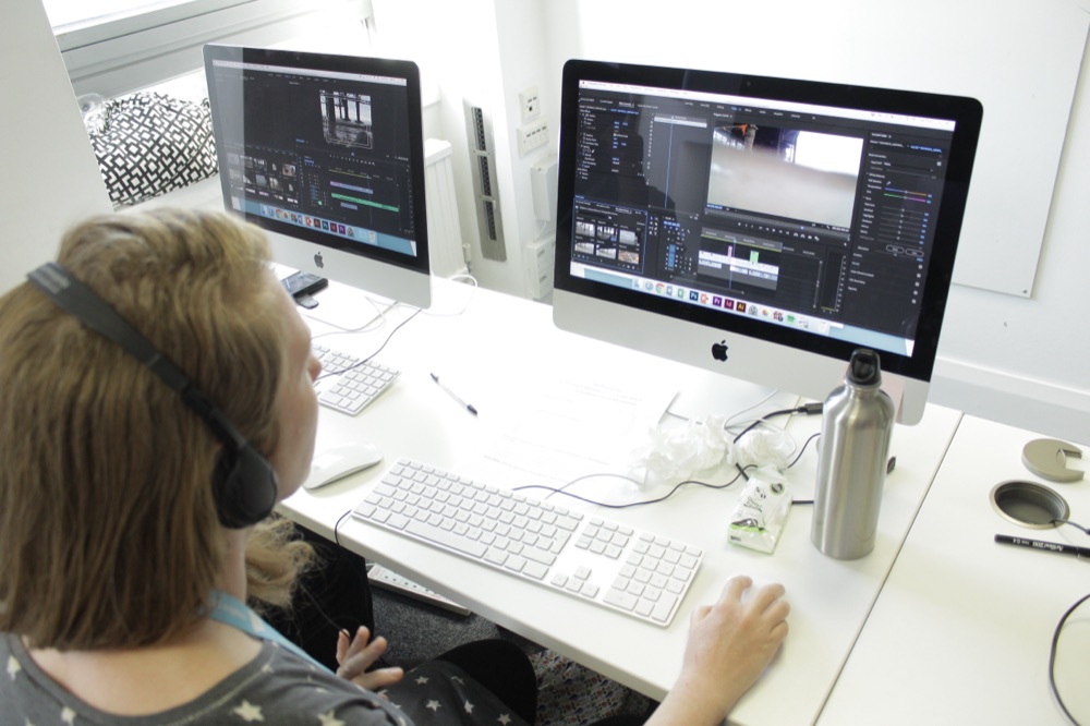 Individual editing video across two screens at a Mac workstation in the CPD Brighton training centre